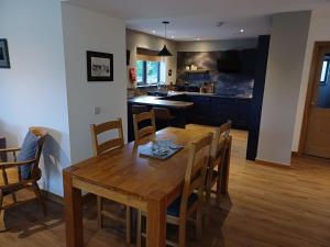 a kitchen and dining room with a wooden table and chairs at Auld Hoose in Kirkwall +3 photos