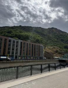 un grand bâtiment avec une montagne en arrière-plan dans l'établissement Ugam revers Apartments, à Khumson