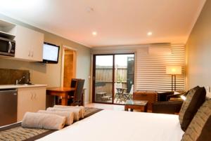 a bedroom with a bed and a kitchen and a living room at Bairnsdale Motel in Bairnsdale