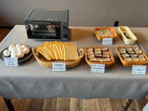 a table with baskets of bread and eggs and a toaster at Shoji Lake Hotel in Fujikawaguchiko