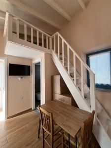 una sala da pranzo con tavolo in legno e scala di Aleminas Rooms 2 a Sými