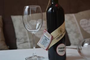 una botella de vino junto a una copa de vino en History Apartments Piata Mare en Sibiu