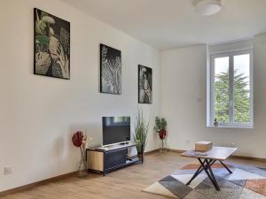 un soggiorno con tv e tavolo di Appartement Zen & Cosy a Ambérieu-en-Bugey