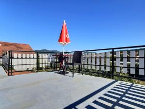 patio con tavolo e ombrellone su una recinzione di Appartement Zen & Cosy a Ambérieu-en-Bugey