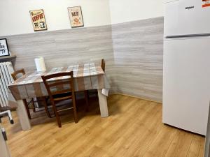 een eetkamer met een tafel en een koelkast bij Nuovo Confortini Rooms SUNDAY in Verona