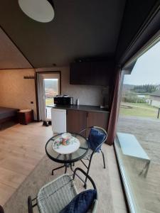 a room with a table and chairs and a kitchen at TORA nameliai in Aukštadvaris
