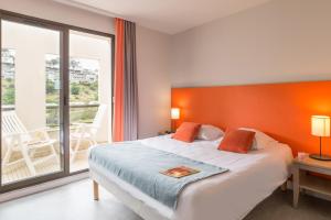 a bedroom with a large bed and a balcony at Résidence Pierre & Vacances L'Archipel in Perros-Guirec