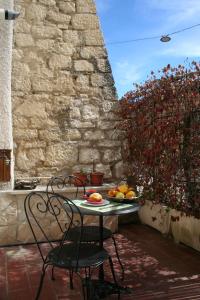 a table and chairs on a patio with a bowl of fruit at Tappetà perì in Campobasso
