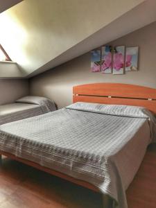 een slaapkamer met 2 bedden en 2 schilderijen aan de muur bij Villa Aresini Relais & Spa in Montemiletto