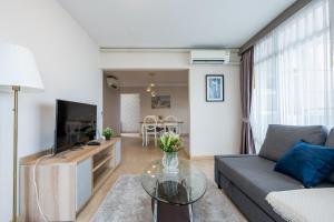 a living room with a couch and a table at Spacious 3BR near Impact, Don Mueang Airport & Pink Line MRT in Nonthaburi