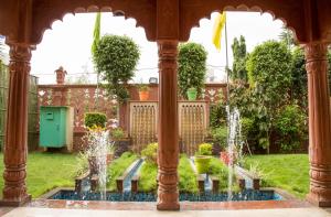 un cenador con fuentes de agua en un jardín en WelcomHeritage Traditional Haveli, en Jaipur