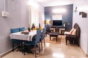 ein Wohnzimmer mit Tisch und Stühlen und einem Fernseher in der Unterkunft Abigail serene stay in Agarvado