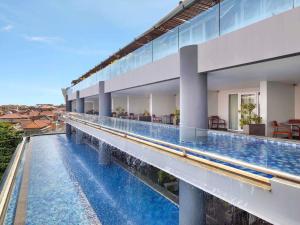 a view of a swimming pool in a building at The Kuta Beach Heritage Hotel - Managed by Accor in Kuta
