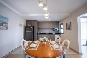 a dining room with a wooden table and chairs at Spacious 3BR near Impact, Don Mueang Airport & Pink Line MRT in Nonthaburi