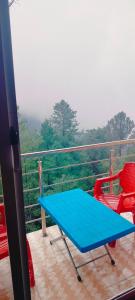 einen blauen Tisch und zwei Stühle auf dem Balkon in der Unterkunft Copacabana Hotel & restaurant in Nathia Gali
