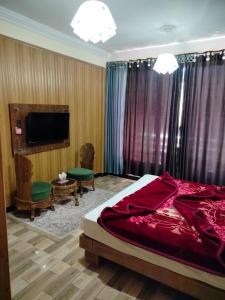 ein Schlafzimmer mit Bett und Flachbildfernseher in der Unterkunft Copacabana Hotel & restaurant in Nathia Gali + 4 Fotos