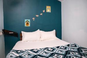 ein Schlafzimmer mit einem Bett mit einer blauen Wand in der Unterkunft Abigail serene stay in Agarvado