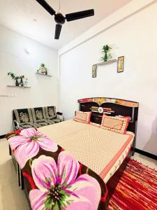 a bedroom with a bed with pink flowers on it at Next Home Stay in Nalkhera