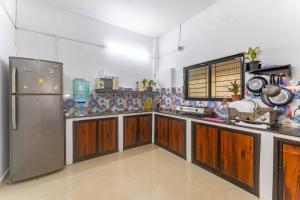 eine Küche mit Holzschränken und einem Kühlschrank in der Unterkunft Abigail serene stay in Agarvado