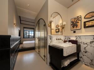 een badkamer met een wastafel en een spiegel bij 龄舍1927酒店 in Wuhan +77 foto's