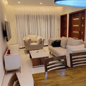ein Wohnzimmer mit Sofa und Tisch in der Unterkunft Residence Helice in Kinshasa