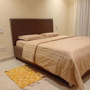 ein Schlafzimmer mit einem Bett und einem Teppich auf dem Boden in der Unterkunft Residence Helice in Kinshasa