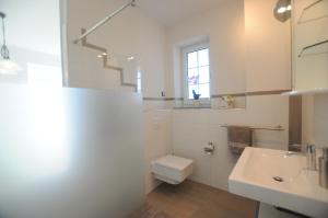 Un baño blanco con inodoro y lavabo. en Villa Toskana, en Rothenburg ob der Tauber 13 fotos más