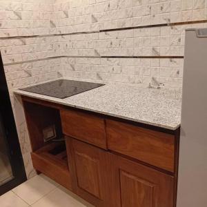 eine Küchentheke mit Spüle und eine Ziegelwand in der Unterkunft Residence Helice in Kinshasa + 3 Fotos