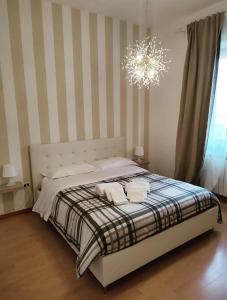 una camera da letto con un letto a righe e un lampadario a braccio di Casa Mamus 2 a Pescara