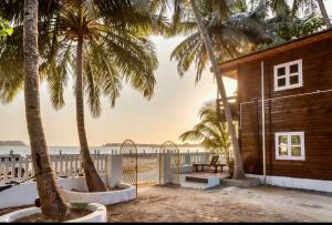 ein Haus am Strand mit Palmen in der Unterkunft Abigail serene stay in Agarvado