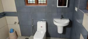 een badkamer met toilet en wastafel bij Valley De Hills Farm Villa in Attappādi +5 foto's