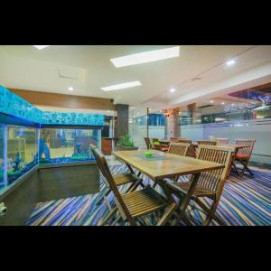 a dining room with a table and chairs and an aquarium at Hotel Marlin Pekalongan Managed by Dafam in Waru Lor