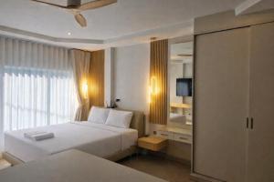 een hotelkamer met twee bedden en een spiegel bij The Escape Kamala in Kamala Beach