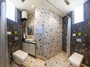 Un baño con dos inodoros y una ducha. en Hotel Golf Sakura, en Gurgaon 27 fotos más