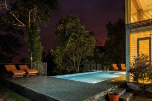 een zwembad in een achtertuin 's nachts bij Stallion Estates in Munnar