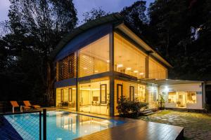 een huis met een zwembad ervoor bij Stallion Estates in Munnar