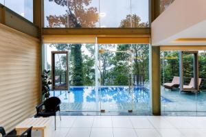 een huis met een zwembad en glazen wanden bij Stallion Estates in Munnar