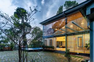 een huis met een groot raam aan de zijkant bij Stallion Estates in Munnar