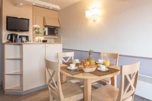 - une cuisine et une salle à manger avec une table et des fruits dans l'établissement Résidence Pierre & Vacances La Promenade des Bains, à Saint-Raphaël