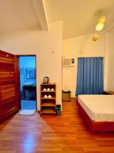 a bedroom with a bed and a blue curtain at Roman Empire Panglao Boutique Resort in Bohol-Panglao International Airport