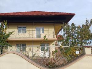 an apartment building with a balcony and trees at Casa Sulfina in Radoşi