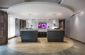 a lobby with two people at the reception desks at Campanile Shanghai Bund Hotel in Shanghai