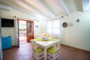 a white table and chairs in a room with a television at S'Omu e Assunta in Cardedu