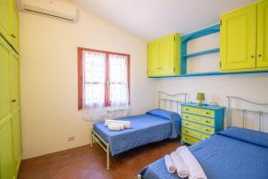 a bedroom with two beds and a dresser and a window at S'Omu e Assunta in Cardedu +5 photos