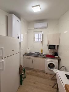 een keuken met een witte koelkast en een spoelbak bij Casa De Los Aguilas in Avila
