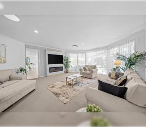 - un salon blanc avec des canapés et une télévision dans l'établissement 4BR Coomera Views! Prime Gold Coast Near Beaches, à Gold Coast