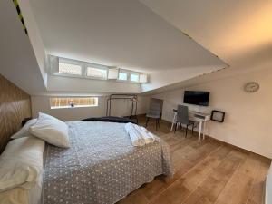 een slaapkamer met een bed, een bureau en een televisie bij Casa De Los Aguilas in Avila