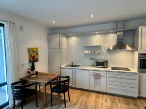 a kitchen with white cabinets and a table and chairs at Fewo KLÜN's 1 in Jever
