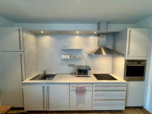 a white kitchen with a sink and a microwave at Fewo KLÜN's 1 in Jever +4 photos