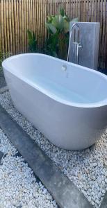 een witte badkuip die op een bed van rotsen staat bij Miramalin Resort Krabi in Ao Nang Beach